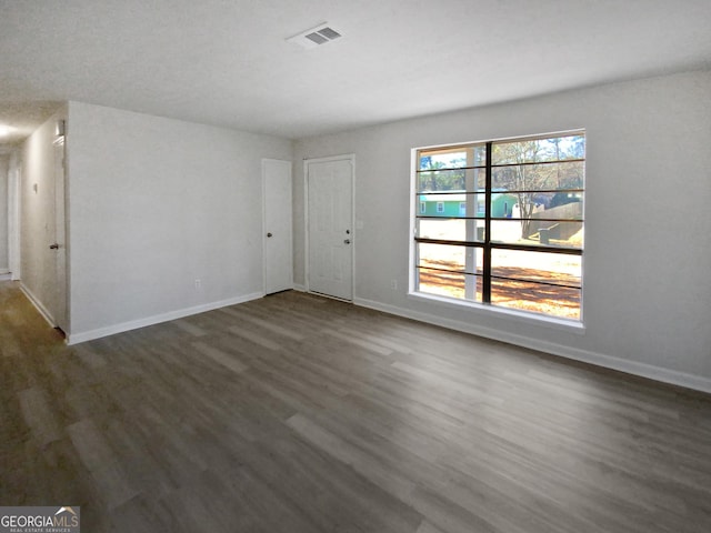 spare room featuring dark wood-type flooring