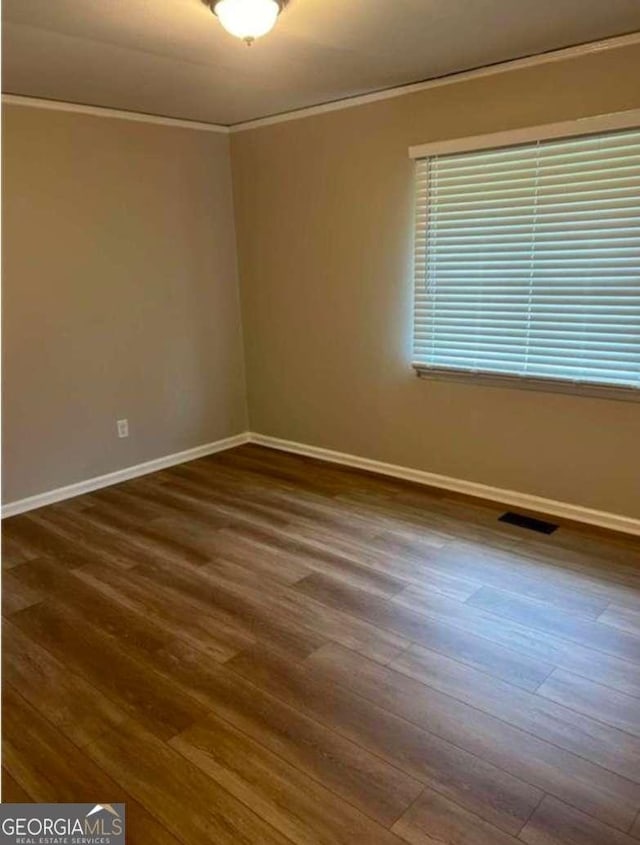 unfurnished room featuring crown molding and dark hardwood / wood-style floors