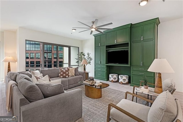 living room with wood-type flooring and ceiling fan