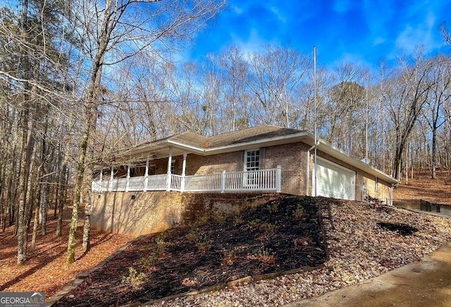 view of side of home featuring a garage and a porch