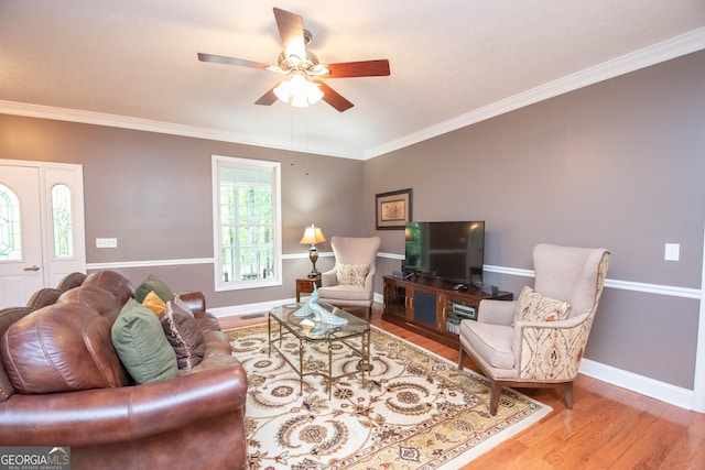 living room with crown molding, wood-type flooring, and ceiling fan