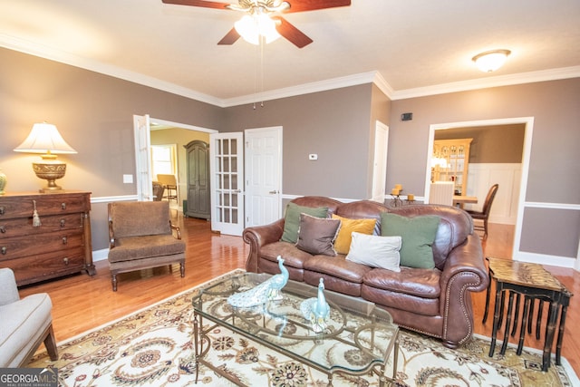 living room with crown molding, ceiling fan, and light wood-type flooring