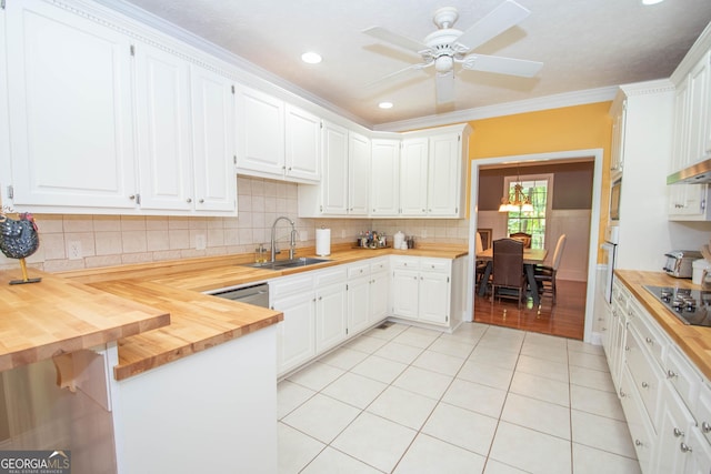 kitchen featuring light tile patterned flooring, butcher block counters, sink, ornamental molding, and white cabinets