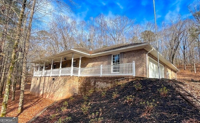 view of side of home featuring a porch and a garage