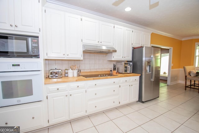 kitchen with wooden counters, black appliances, ornamental molding, white cabinets, and backsplash