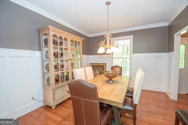 dining room featuring crown molding, light hardwood / wood-style flooring, and a chandelier