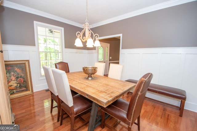 dining area featuring crown molding, a chandelier, and hardwood / wood-style floors