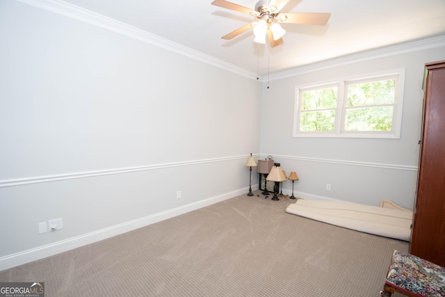 carpeted spare room with ornamental molding and ceiling fan