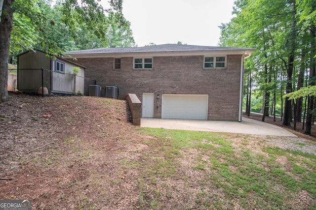 rear view of house featuring a garage and central AC unit