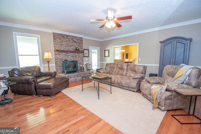 living room featuring wood-type flooring, crown molding, ceiling fan, and a textured ceiling