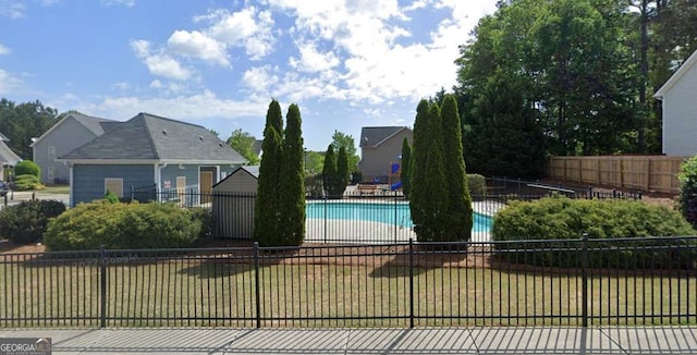 view of swimming pool with a yard