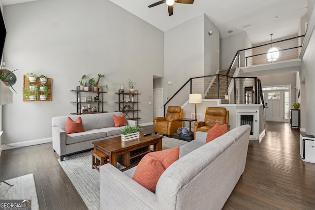 living room with ceiling fan, dark wood-type flooring, and high vaulted ceiling