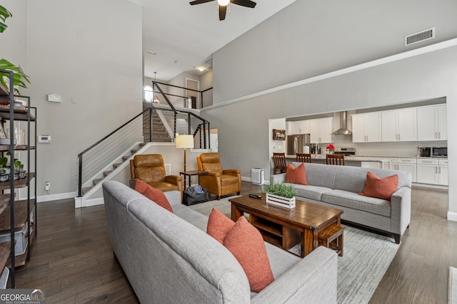 living room with sink, dark wood-type flooring, ceiling fan, and a high ceiling