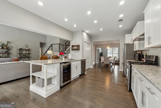 kitchen featuring wine cooler, sink, white cabinetry, light stone counters, and appliances with stainless steel finishes