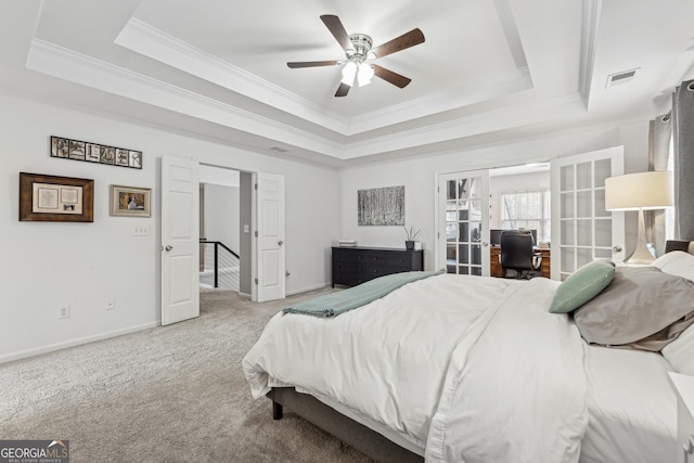 carpeted bedroom with a raised ceiling, ornamental molding, ceiling fan, and french doors