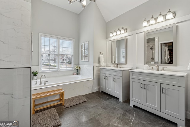 bathroom with vanity, vaulted ceiling, and shower with separate bathtub