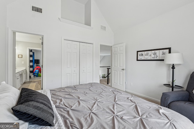 carpeted bedroom with high vaulted ceiling, a closet, and ensuite bathroom