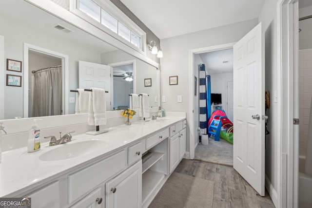 bathroom featuring wood-type flooring, vanity, and ceiling fan