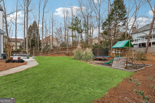 view of yard featuring a playground and a trampoline