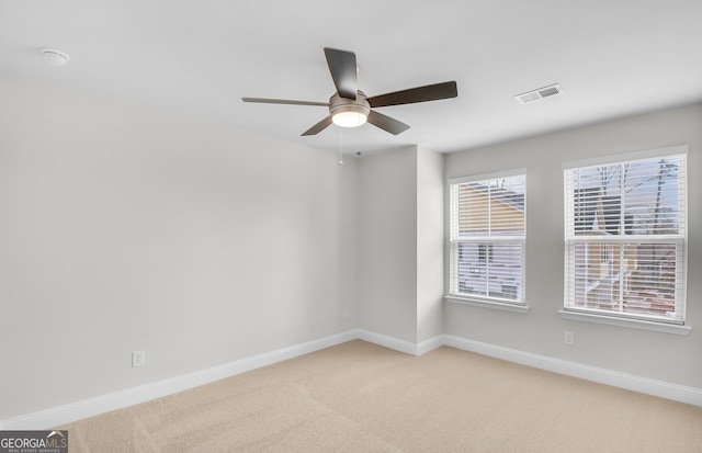 carpeted spare room featuring ceiling fan