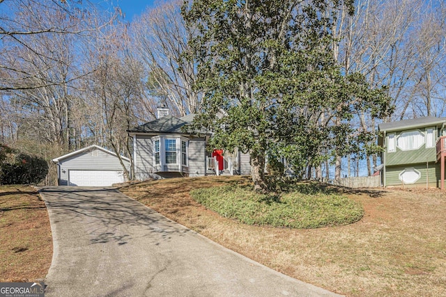 view of front of property with a garage, an outdoor structure, and a front yard