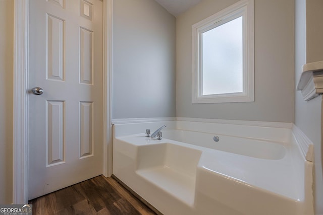 bathroom featuring wood-type flooring and a bathtub