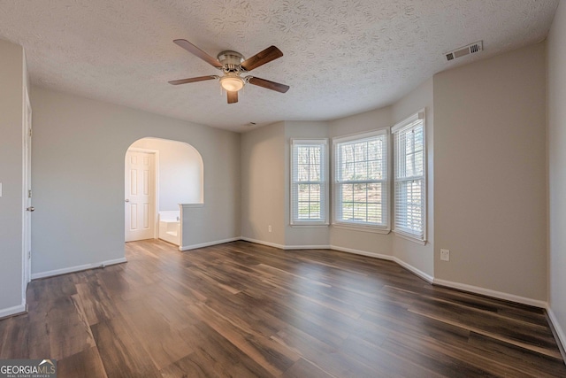 empty room featuring ceiling fan, a textured ceiling, and dark hardwood / wood-style flooring