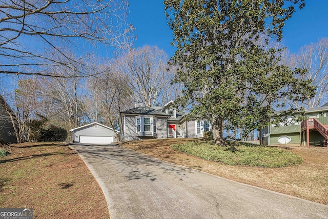 view of front of home featuring a garage, an outdoor structure, and a front lawn