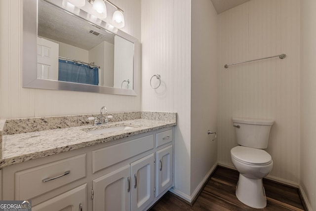 bathroom featuring vanity, hardwood / wood-style floors, curtained shower, and toilet