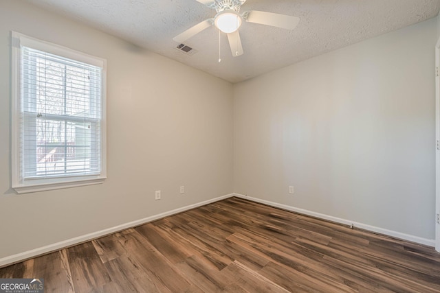 spare room featuring ceiling fan, dark hardwood / wood-style flooring, and a textured ceiling