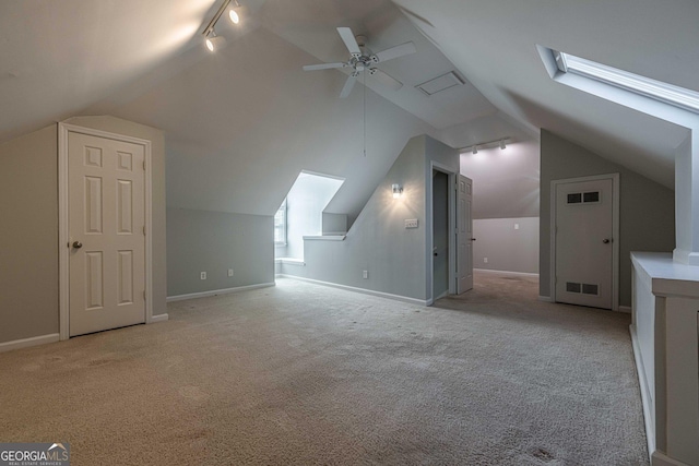 bonus room featuring light carpet, vaulted ceiling with skylight, and ceiling fan