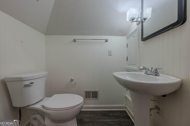 bathroom with lofted ceiling, hardwood / wood-style floors, sink, and toilet