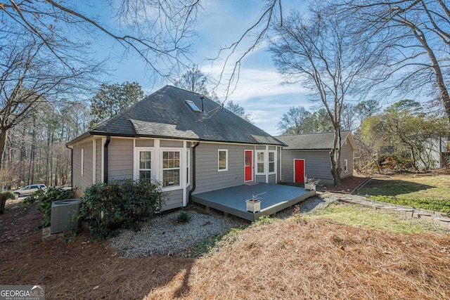 back of property featuring a wooden deck, a yard, and central AC