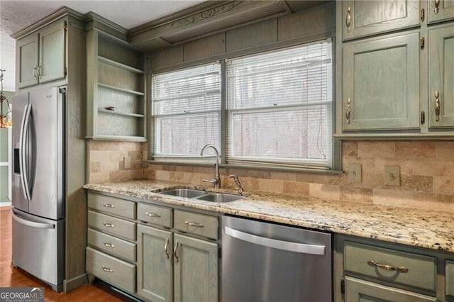 kitchen with light stone counters, sink, stainless steel appliances, and dark hardwood / wood-style floors