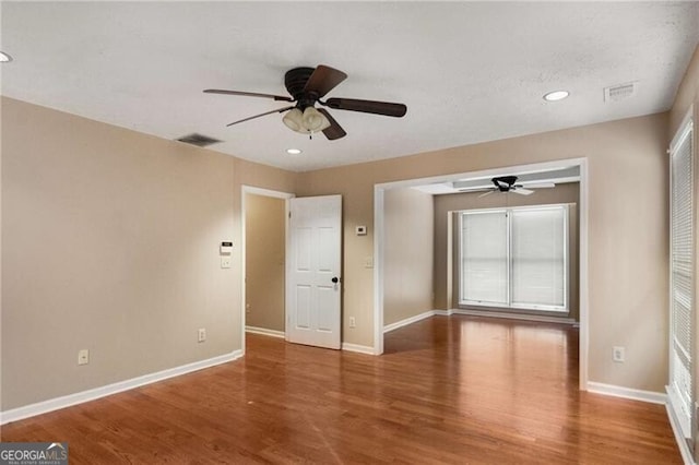 spare room with ceiling fan and wood-type flooring