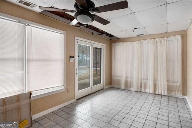 unfurnished room with a drop ceiling, ceiling fan, and light tile patterned flooring