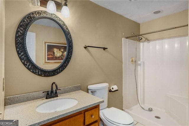 bathroom with vanity, toilet, and walk in shower