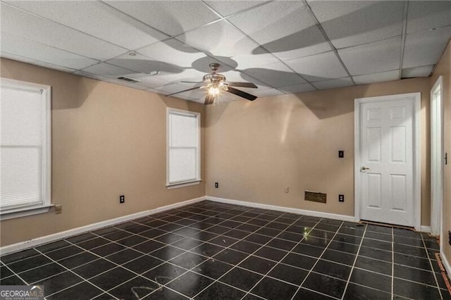 spare room with a drop ceiling and ceiling fan