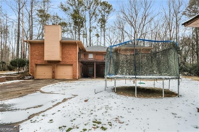 snowy yard featuring a garage