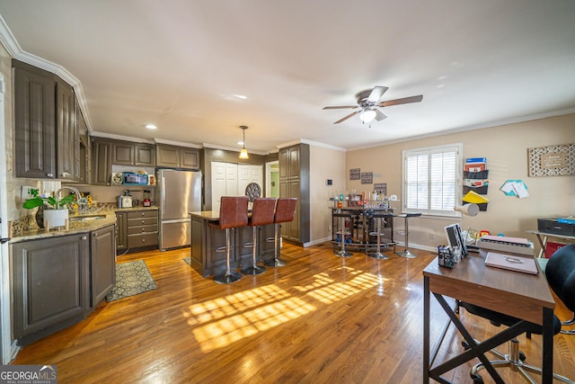 office area featuring hardwood / wood-style flooring, crown molding, and sink