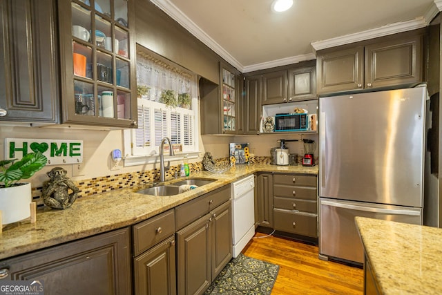 kitchen featuring stainless steel refrigerator, dark brown cabinetry, white dishwasher, and sink