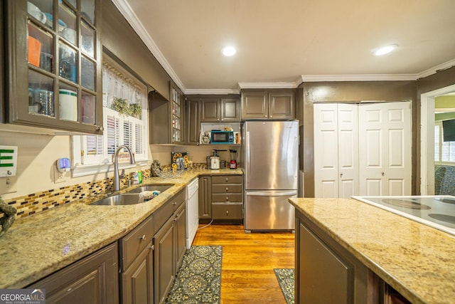 kitchen with sink, stainless steel fridge, white dishwasher, light hardwood / wood-style floors, and crown molding