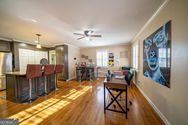 office featuring dark hardwood / wood-style flooring, ornamental molding, ceiling fan, and indoor bar