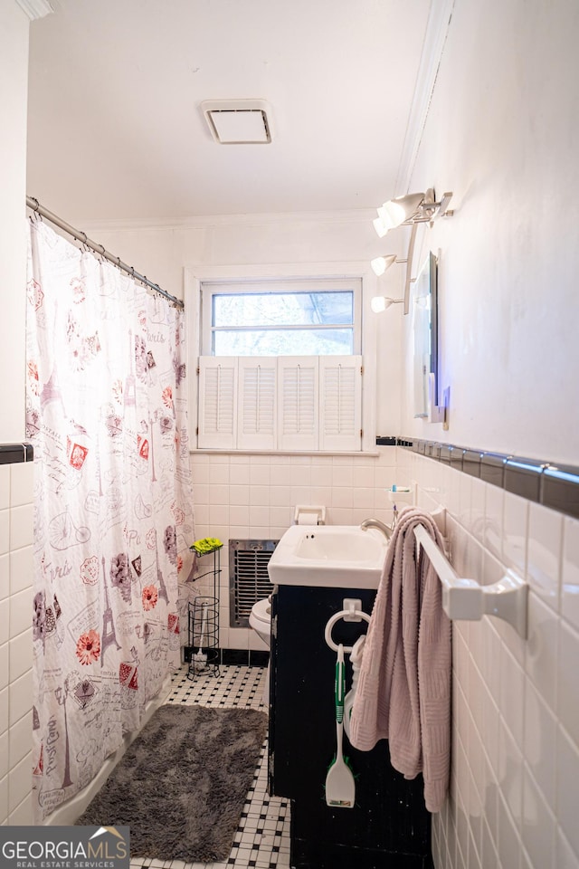 bathroom featuring tile walls, vanity, heating unit, ornamental molding, and toilet