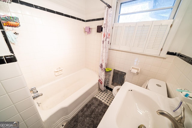 full bathroom featuring shower / tub combo with curtain, toilet, sink, and tile walls