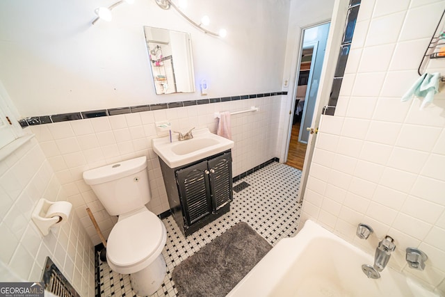 bathroom with vanity, toilet, tile patterned flooring, and tile walls