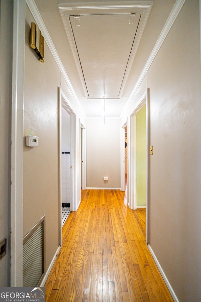 hallway featuring ornamental molding and light wood-type flooring