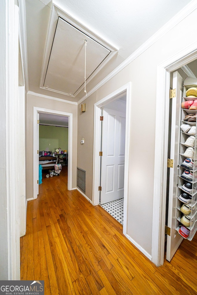 hallway with crown molding and hardwood / wood-style floors