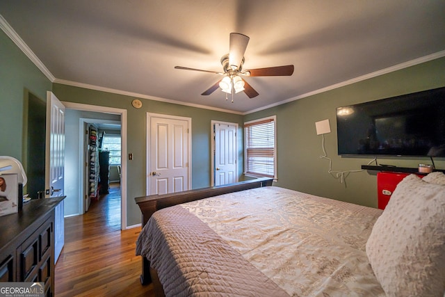 bedroom with crown molding, dark hardwood / wood-style floors, and ceiling fan