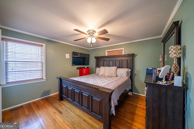 bedroom featuring ornamental molding, ceiling fan, and light hardwood / wood-style flooring